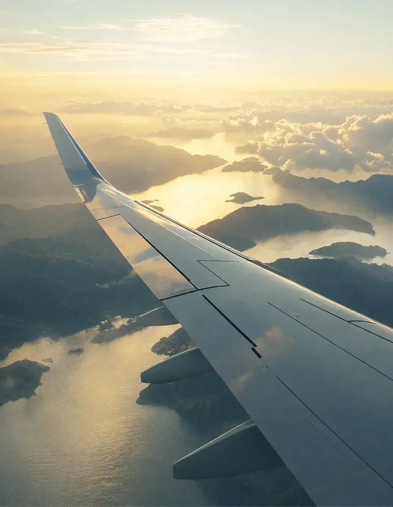Aircraft wing above the clouds at sunrise